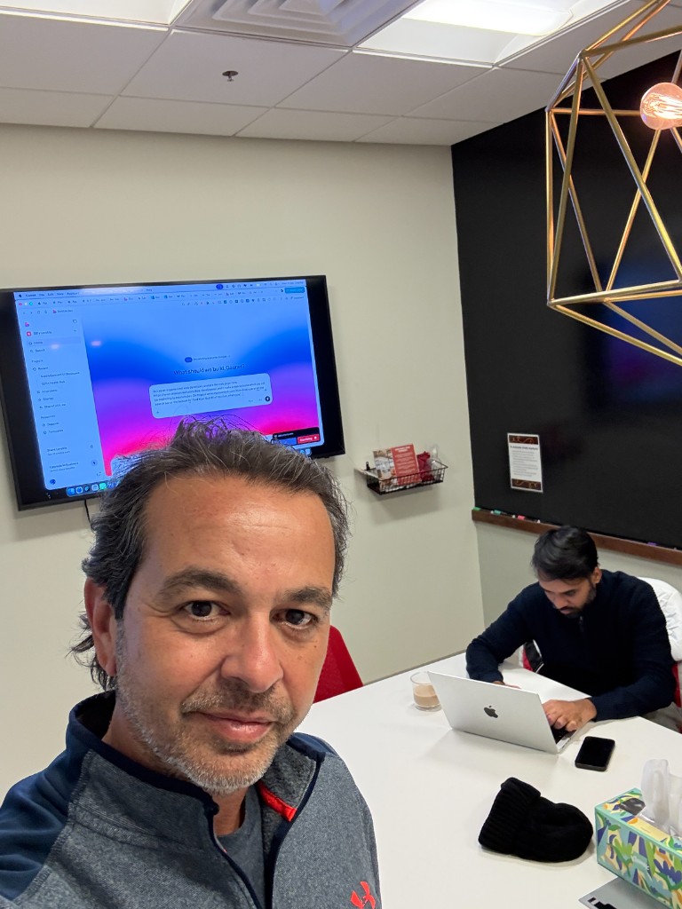 Antonio Chagoury in a modern office, teammate working at a table in the background