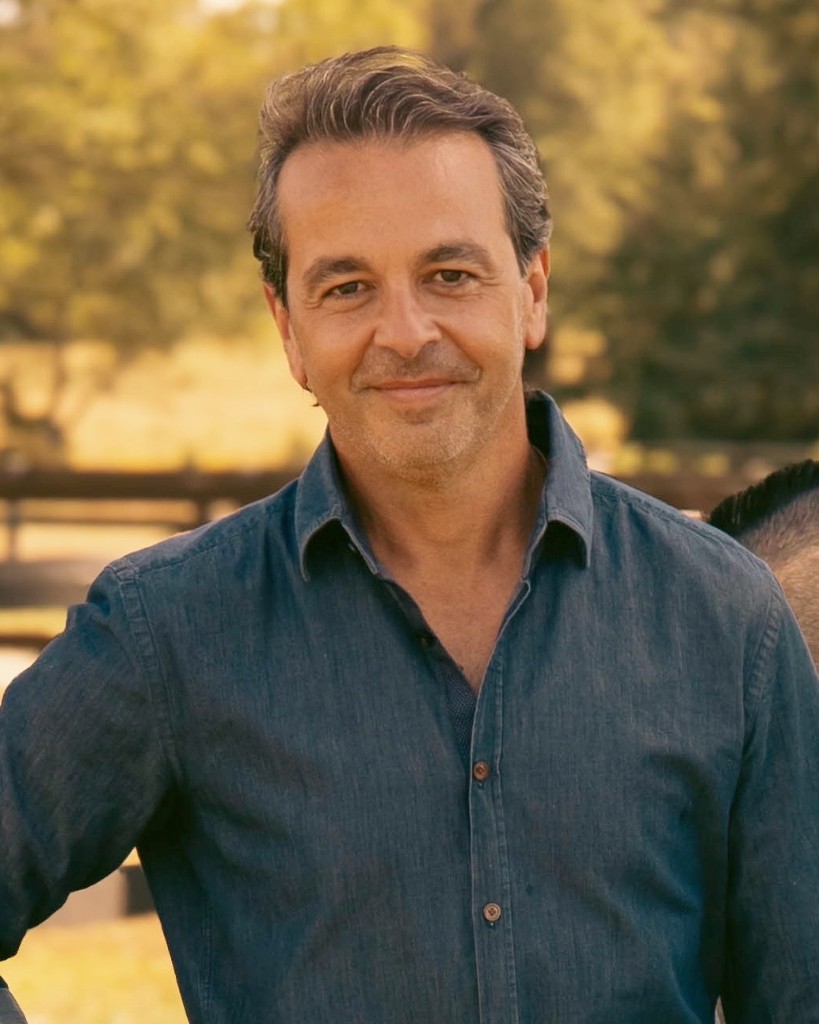 Antonio Chagoury — portrait outdoors in a blue denim shirt, warm golden light